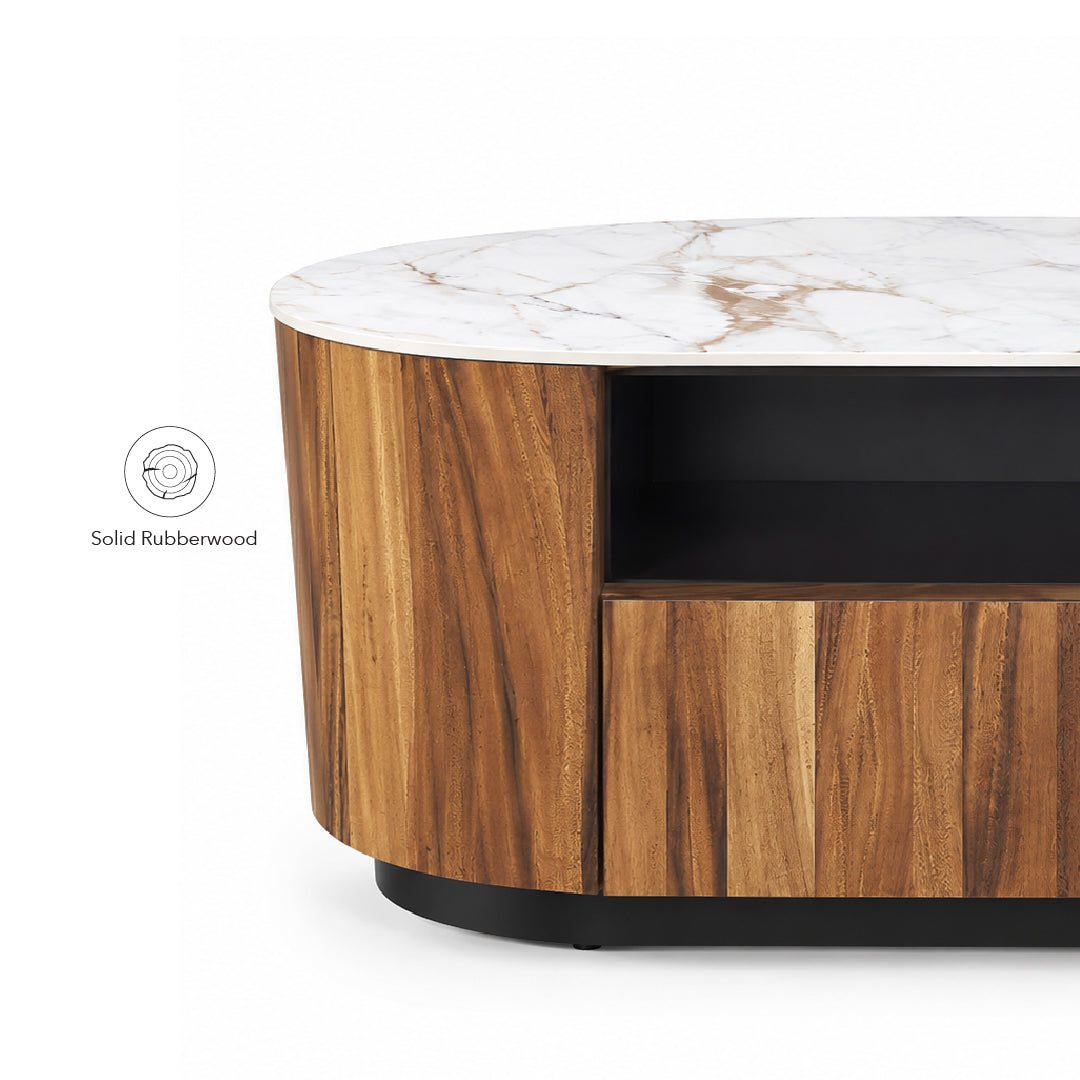 Close-up of a modern round coffee table with a white marble-look top, warm medium-brown wood grain sides, a black open shelf, and a black base. A small inset callout reads 'Solid Rubberwood' on a white background.