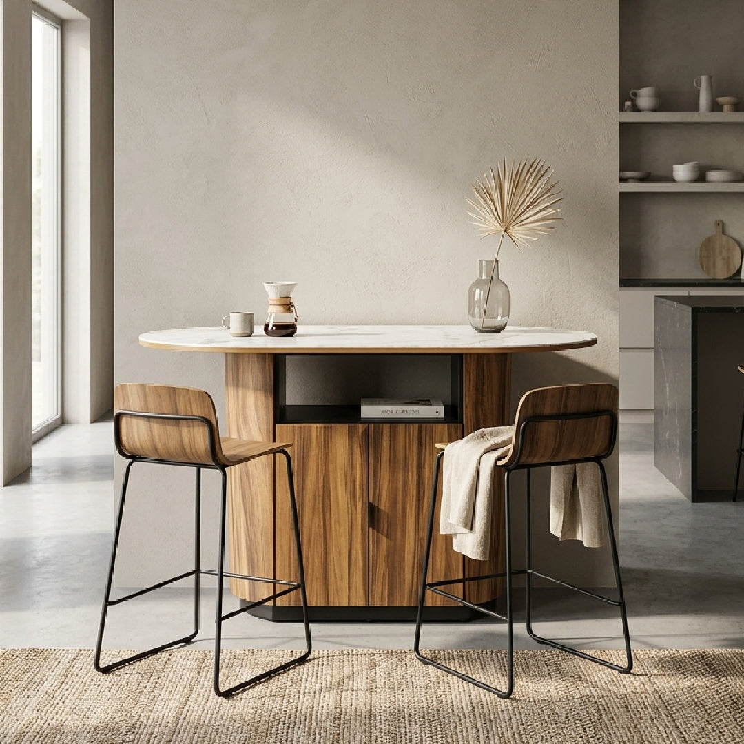 A modern kitchen island with a solid rubberwood and monkey pod wood veneer base cabinet, a white sintered stone top, and two matching island stools with wood seats and black metal frames, set in a minimalist kitchen interior