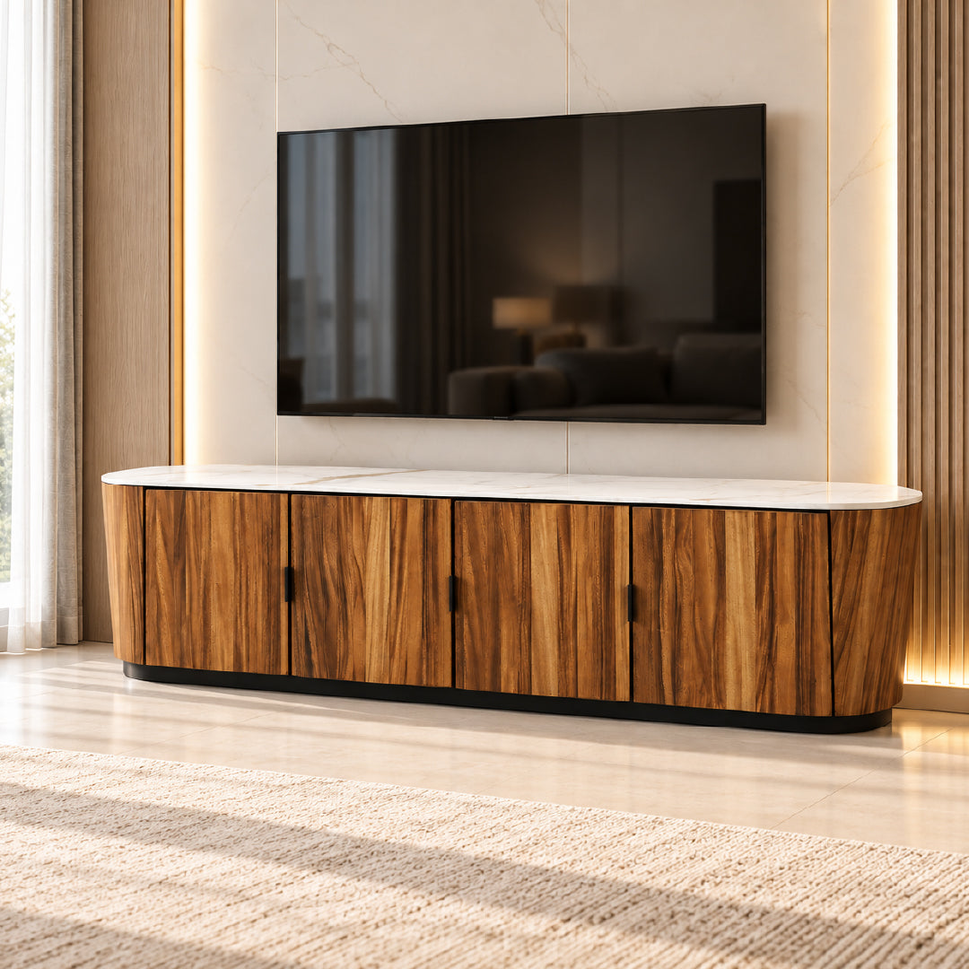 A modern curved tv cabinet with a white marble-look top and vertical wood grain doors, shown in a styled living room setting with a TV mounted on the wall above it.