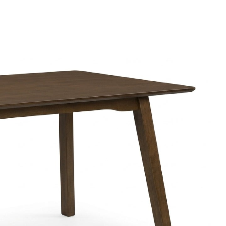 Close-up of a dark brown wooden dining table showing the tabletop corner and one angled leg against a plain white background.