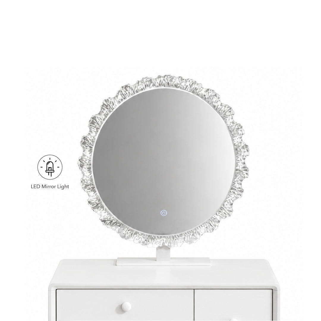 A round LED vanity mirror with a textured, ruffled silver frame, shown resting on a white drawer cabinet against a white background. A small graphic icon on the left indicates the built-in LED mirror light.