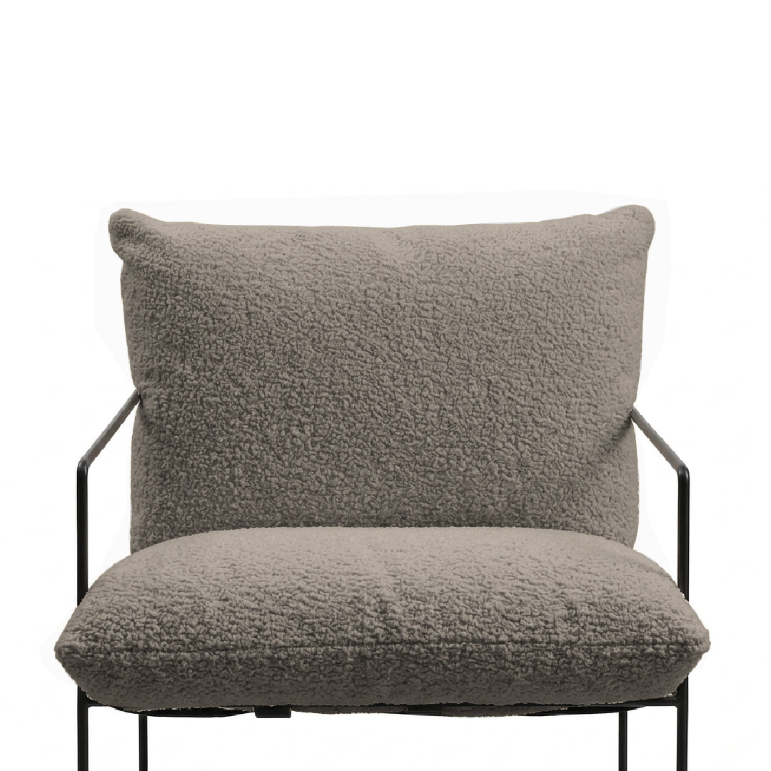 A modern lounge chair with a plush, textured bouclé seat cushion and a matching back cushion on a black metal frame, shown against a plain white background.