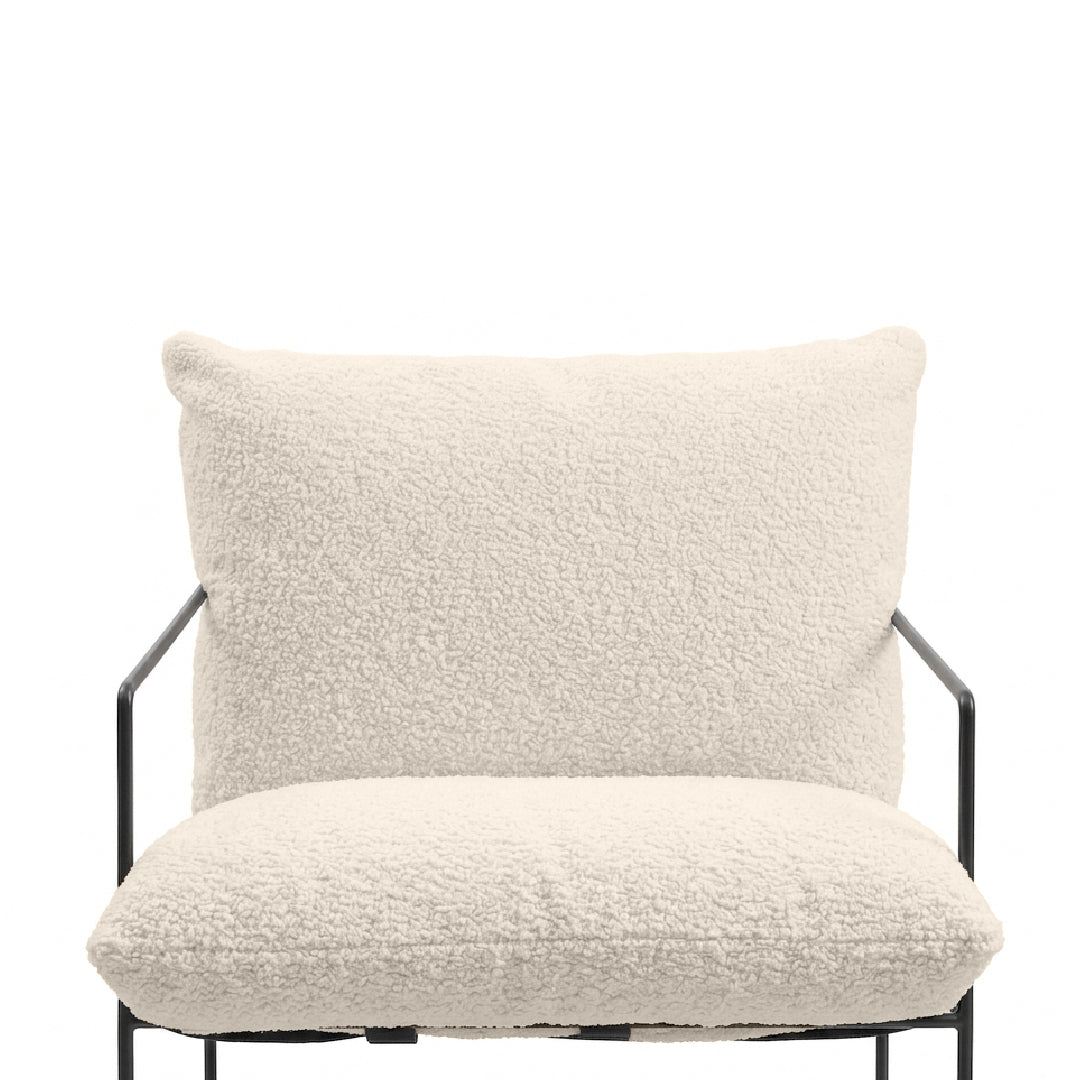 An off-white bouclé upholstered armchair with a black metal frame, shown against a solid white background.
