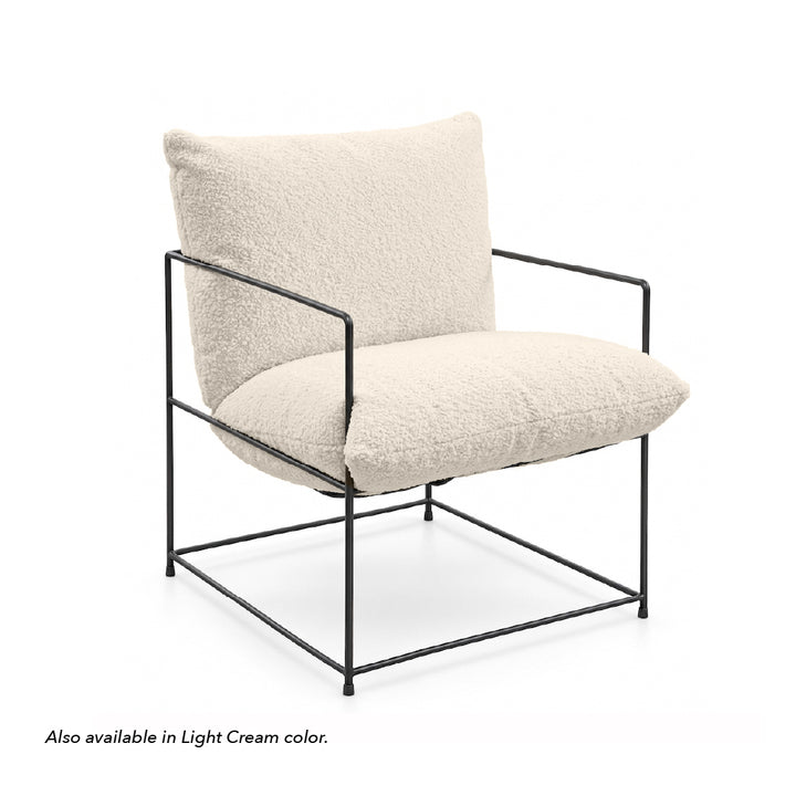 A modern accent chair with textured cream boucle cushions and a black metal frame, shown on a white background with a small text note at the bottom left.