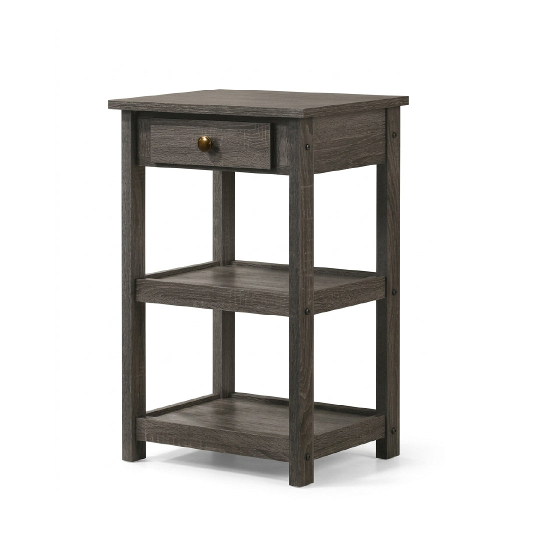 A rustic three-tier side table in a weathered dark gray wood finish, featuring a single drawer with a small brass knob on the top shelf, set against a plain white background.