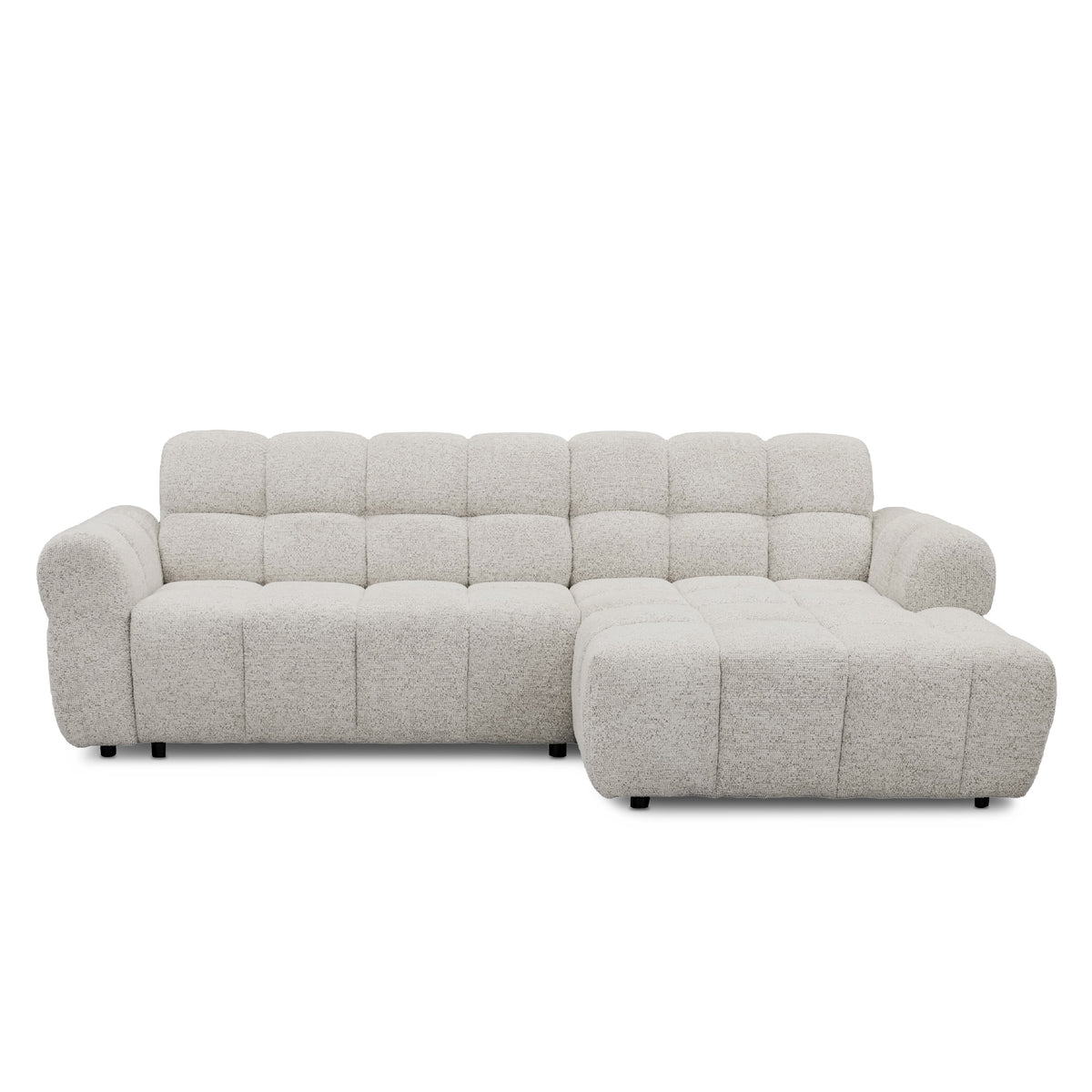 A modern l-shape sofa upholstered in a textured light grey bouclé fabric, featuring a tufted backrest and a right-side chaise lounge, shown against a plain white background.