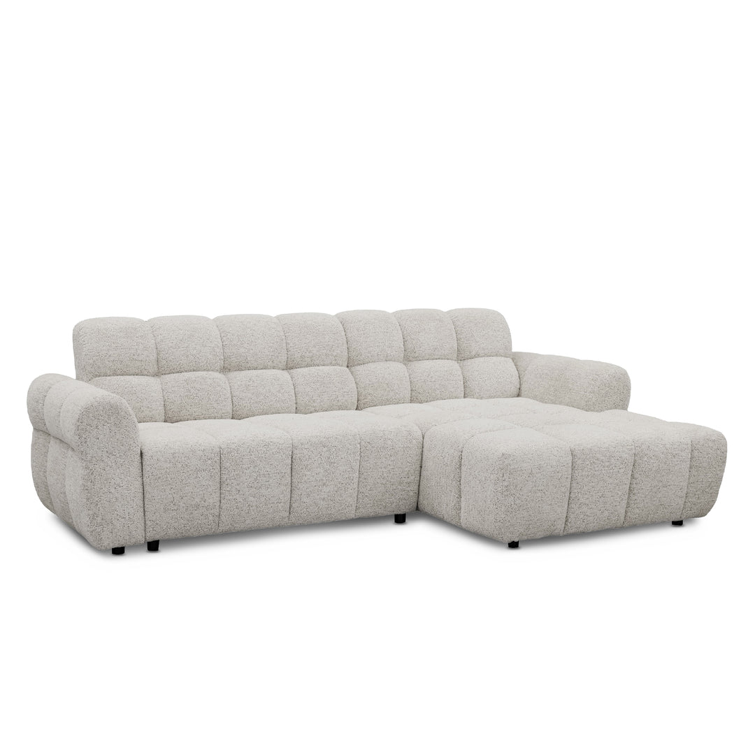 A light grey textured boucle l-shape sofa with a right-facing chaise lounge, featuring a tufted backrest and chunky armrests, shown against a plain white background.