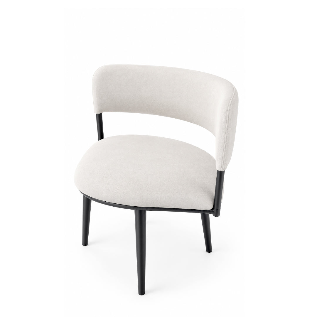 A modern accent chair with a curved, upholstered backrest and seat in a light beige fabric, supported by slim black metal legs, shown against a plain white background.