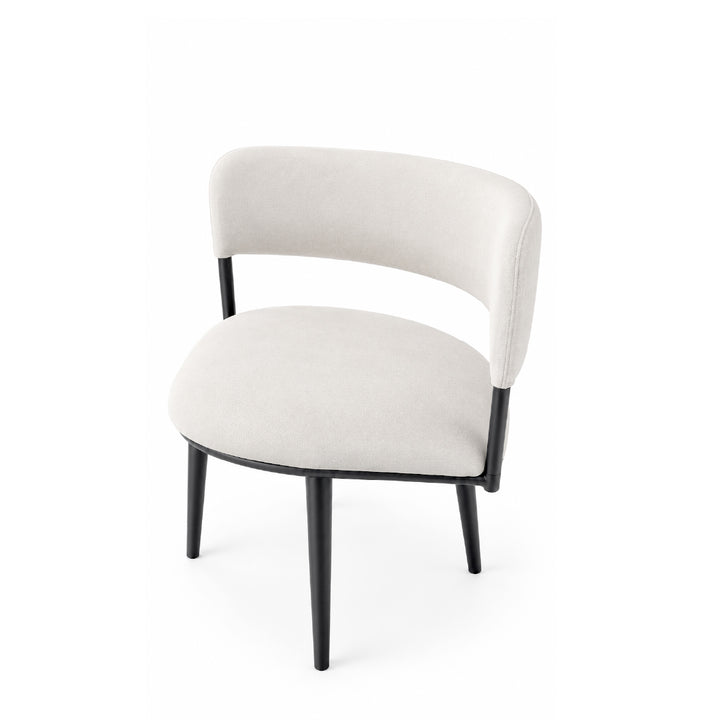 A modern accent chair with a curved, upholstered backrest and seat in a light beige fabric, supported by slim black metal legs, shown against a plain white background.