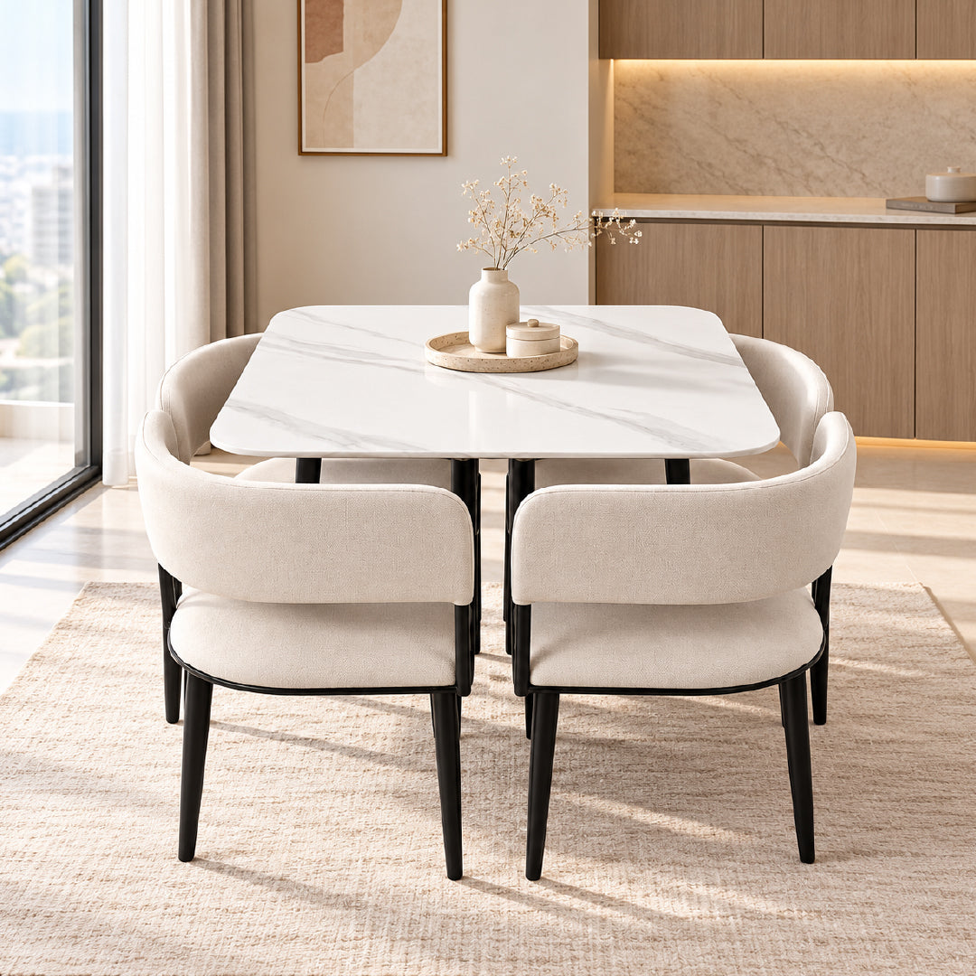 A modern dining set featuring a white marble-patterned rectangular table with black legs, surrounded by four upholstered chairs in a warm beige fabric with black legs, set on a textured rug in a contemporary dining room.