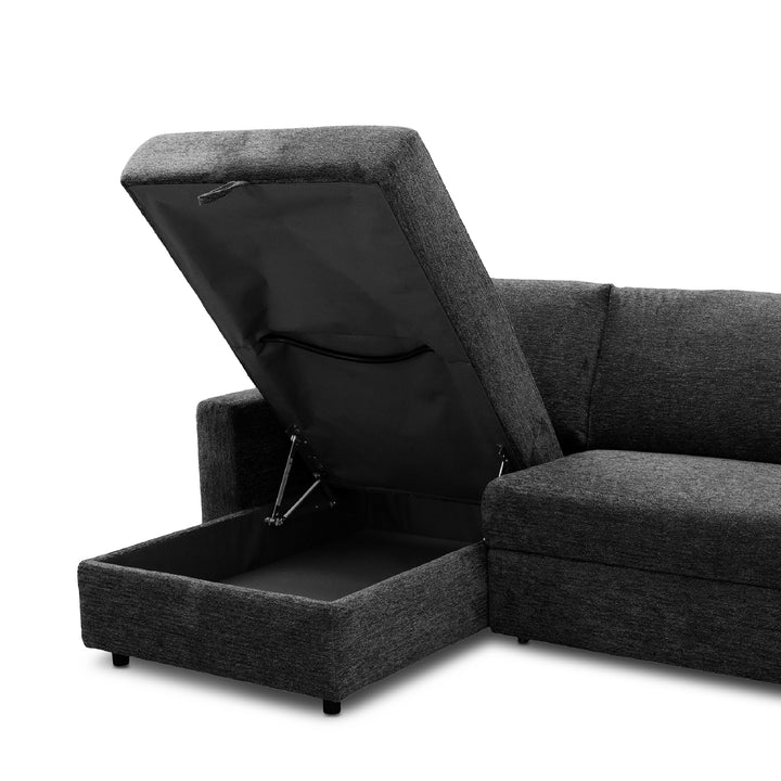 Dark gray textured fabric sectional sofa-bed with a lift-up ottoman seat section open to reveal storage space underneath, shown on a white background.