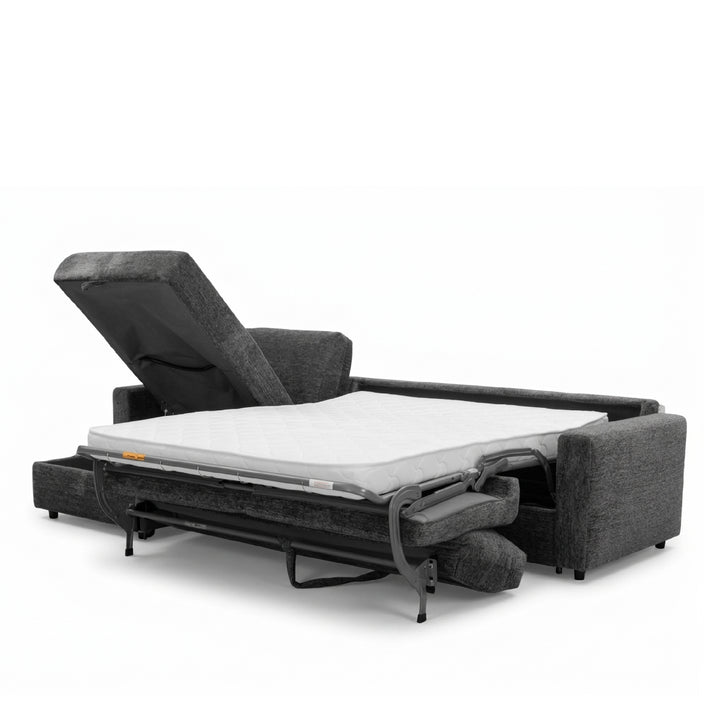 A dark gray upholstered sofa bed shown in a partially extended position, with a white mattress on top and the headrest raised, photographed on a clean white studio background.