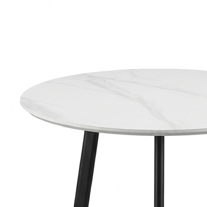 A close-up of a round dining table with a white marble-patterned top and black metal legs, shown against a plain white background.