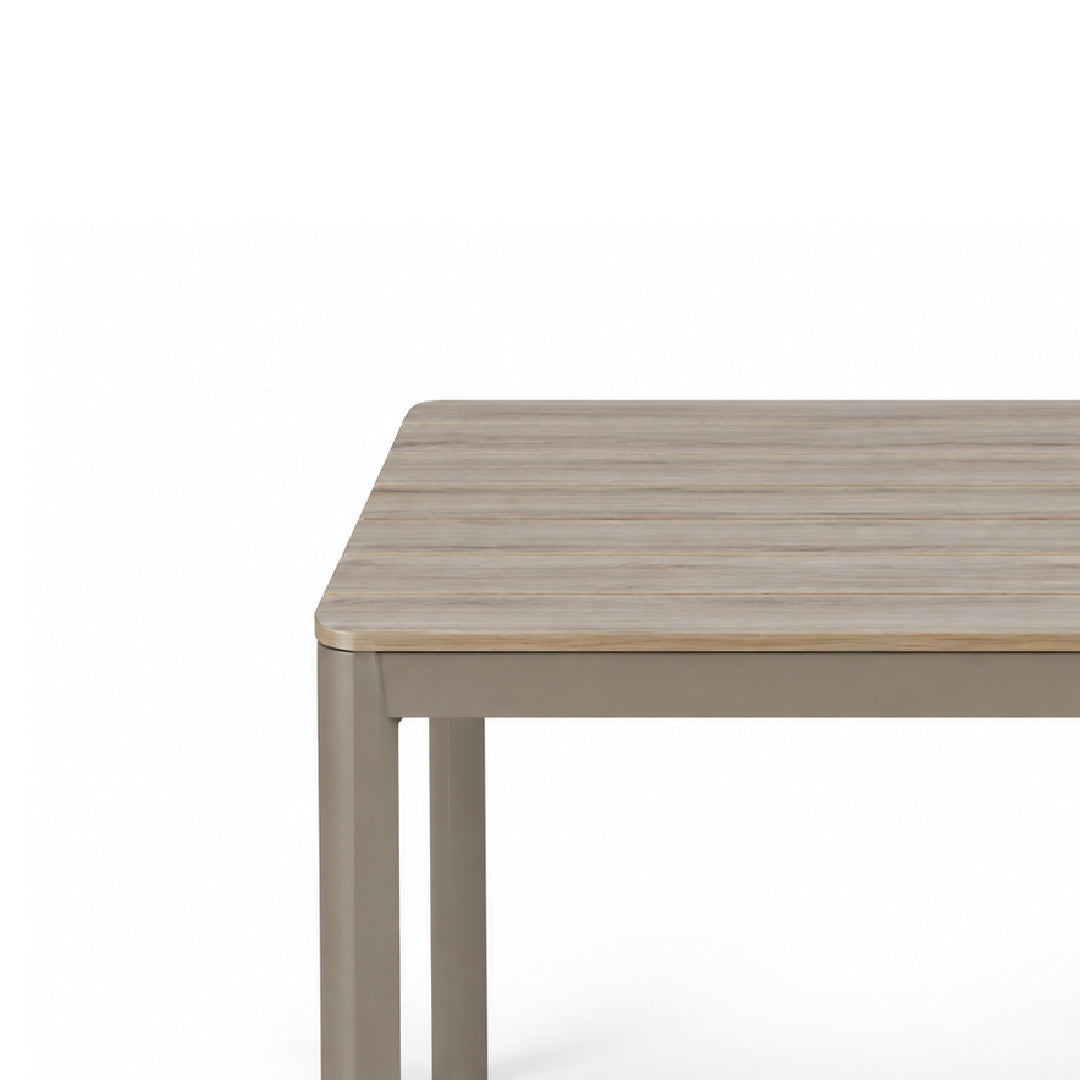 Close-up of a rectangular outdoor table corner, showing a light natural wood slatted top and a taupe metal frame leg on a white background.
