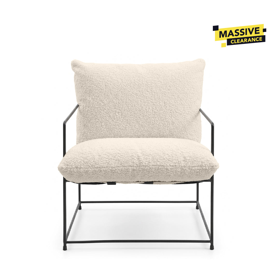 A modern accent chair with a textured cream bouclé seat cushion and backrest, supported by a slim black metal frame, shown against a plain white background.